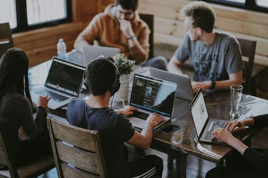 A team of professionals collaborating around a laptop
